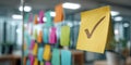 Colorful sticky notes on a glass wall with a checkmark representing accomplished tasks in an office space Royalty Free Stock Photo