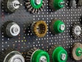Collection of various wire brushes and tools arranged on a textured display board in a workshop setting Royalty Free Stock Photo