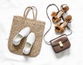 Variety of women`s shoes and bags - straw shopper bag and sneakers and  elegant leather cross body bag and suede sandals on a Royalty Free Stock Photo