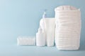 Various accessories for children's hygiene. A large stack of diapers next to them are bottles of baby cosmetics. Royalty Free Stock Photo