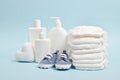 Various accessories for children's hygiene. A large stack of diapers next to them are bottles of baby cosmetics. Royalty Free Stock Photo