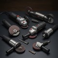 Various angle grinders are arranged on a dark surface. Each has a rotating abrasive Royalty Free Stock Photo