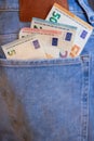 Money euro banknotes in blue trousers pocket. Close up money in back pocket. Royalty Free Stock Photo