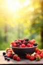 Various berries in a bowl against the backdrop of the garden. Selective focus. Royalty Free Stock Photo