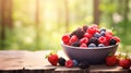 Various berries in a bowl against the backdrop of the garden. Selective focus. Royalty Free Stock Photo