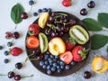 Various berries and fruits on a wooden plate Royalty Free Stock Photo