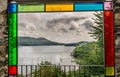 A yacht on a lake viewed through coloured glass frame.