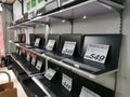 Various brand and model of refurbished laptop on shelf with price tags.