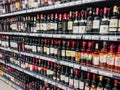 Various brands of red and pink wine on the shelves of the supermarket.