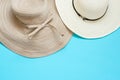 Various broad brimmed women`s straw hats on light mint blue background. Summer vacation fashion accessories beach