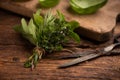 Various bundles of fresh herbs on a wooden background