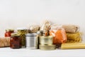 Various canned food and raw cereal grains on a table