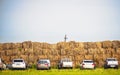 Various Cars Parked By the Stack Hay High Wall in Countryside. Agricultural Farming or Building the Wall, Barrier Concept