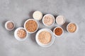 Various cereals and beans in white plates on gray textured table Royalty Free Stock Photo