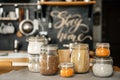 Various cereals Buckwheat, lentils, oatmeal, pasta, are stored in glass jars on the background of the kitchen and the inscription