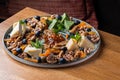 various cheeses on a plate with nuts and confitures.