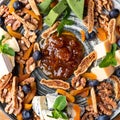 various cheeses on a plate with nuts and confitures. Royalty Free Stock Photo