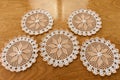 Various circular towels made in crochet in white and beige colors on wooden background