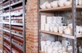Various clay mugs and cups on racks in pottery shop