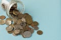 Various coins are scattered on a blue background. The concept of poverty. Selective focus