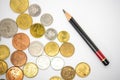 Various coins and pencil