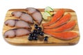 Various cold smoked fish slices: sturgeon, tuna with olives on wooden board isolated Royalty Free Stock Photo