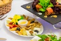 Various cold snacks on the table in the restaurant: cheese, salmon, vegetables and more Royalty Free Stock Photo