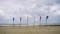 Various color of flags on wooden poles at the Batu Burok Beach Royalty Free Stock Photo