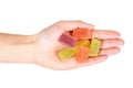 Various color of fruity gummy jelly candies in hand isolated on white background