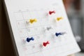 Various color thumb tack pins on calendar as reminder