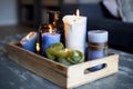 Various colored burning candles on wooden table in modern home, in wooden retro box, cozy style interior decoration