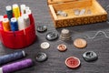 Various colored buttons for clothes lie on the table. Sewing accessories are lying next to you. Sewing a button to clothes. The ne Royalty Free Stock Photo