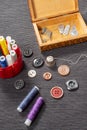 Various colored buttons for clothes lie on the table. Sewing accessories are lying next to you. Sewing a button to clothes. The ne Royalty Free Stock Photo