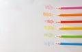 Various colored pencils on white striped paper top view Royalty Free Stock Photo