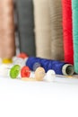 Various colored spools and buttons on an needle housework hobby tailoring concept Royalty Free Stock Photo