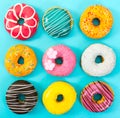 Various colorful donuts on blue background. Royalty Free Stock Photo