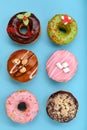 Various colorful donuts on blue background. Top view. Royalty Free Stock Photo