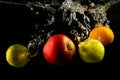 Various fruits pear, orange and apple splash of water on black