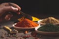 Various colorful herbs and spices on wooden table. hand with a spoon . Dark background, selective focus. with copy space. Cooking Royalty Free Stock Photo