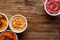 Various colorful hummus with addition of baked beetroots, grilled pepper and pumpkin on a wooden background