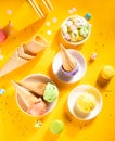 Various colorful ice cream scoops or balls with waffle cones on yellow background. Top view Royalty Free Stock Photo