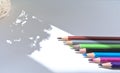 Various colorful pencils on white background. Light shines on the penpoint