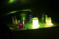 Various colourful light induced catalyst photochemical reaction in glass vials under green light in a dark chemistry laboratory