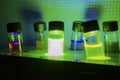 Various colourful light induced catalyst photochemical reaction side view in glass vial under green light in a dark chemistry