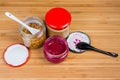 Various condiments in small glass jars on a wooden surface Royalty Free Stock Photo