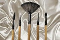 Various cosmetic brushes above fabric