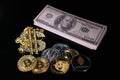 Various crypto coins lie next to a stack of 100-dollar bills, a white alarm clock and a diamond-studded dollar chain pendant Royalty Free Stock Photo