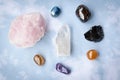 Various crystals or raw gemstone minerals with light blue background.