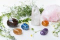 Various crystals or raw gemstone minerals with wild flowers.