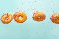 Various decorated donuts in motion falling on a blue background. Sweet and iced donuts fall or fly in motion. With caramel. Royalty Free Stock Photo